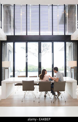 Couple using tablet pc in dining room Banque D'Images