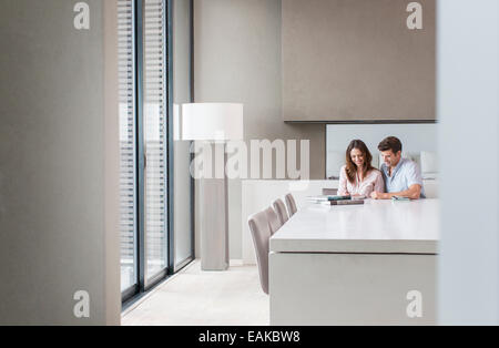 Couple using tablet pc in dining room Banque D'Images