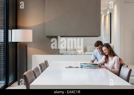 Couple using tablet pc in dining room Banque D'Images