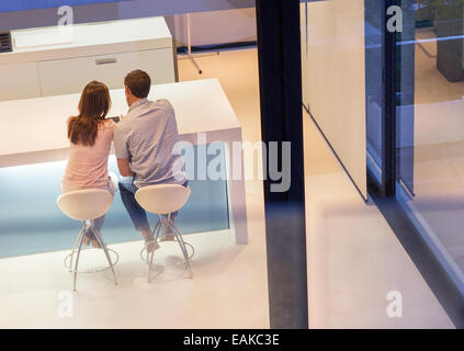 Vue arrière du couple using tablet pc in dining room Banque D'Images