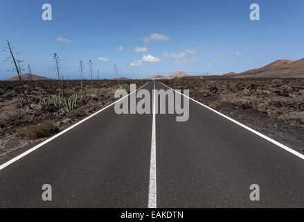 Route à travers un paysage volcanique, près de Mancha Blanca, Lanzarote, îles Canaries, Espagne Banque D'Images