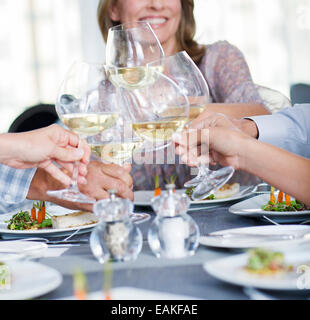 People toasting with white wine in restaurant Banque D'Images