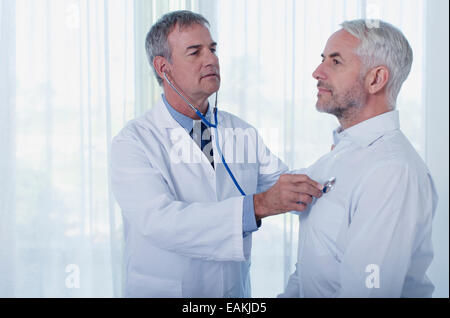 Doctor examining Young man with stethoscope Banque D'Images