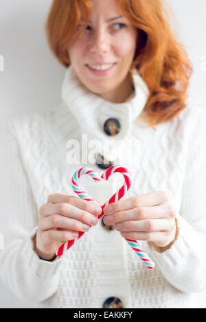 Cute girl holding cannes de bonbons en forme de cœur Banque D'Images