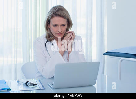 Female doctor sitting at desk in office Banque D'Images