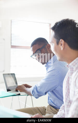 Les hommes d'affaires travaillant avec laptop in office Banque D'Images