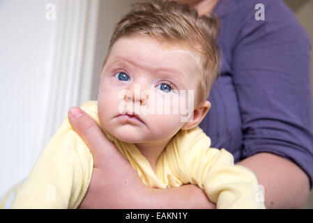 Petite fille de 12 semaines avec des yeux bleus et beaucoup de cheveux blonds Banque D'Images