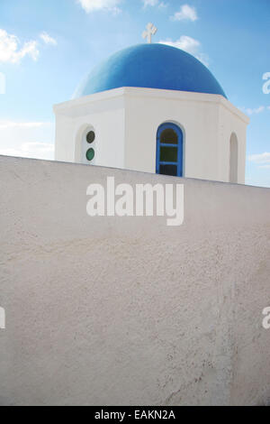 L'église blanche traditionnelle avec un dôme bleu, perché sur le côté de la falaise, Oia, Santorini, Cyclades, Grèce. Banque D'Images