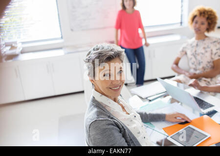 Portrait of smiling mature businesswoman at desk in office Banque D'Images