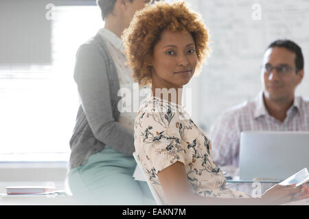 Portrait of businesswoman in office, des collègues en arrière-plan Banque D'Images