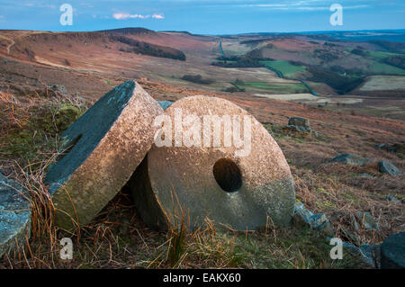 Meules en dessous de Stanage edge au coucher du soleil. Vue sur le paysage coloré au-delà de la route au loin. Banque D'Images