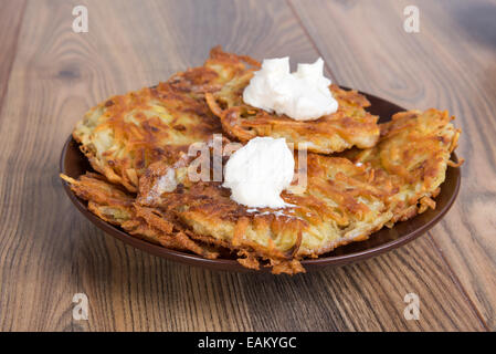 Les galettes de pommes de terre - draniki - avec de la crème - le plat national de la cuisine ukrainienne et biélorusse Banque D'Images