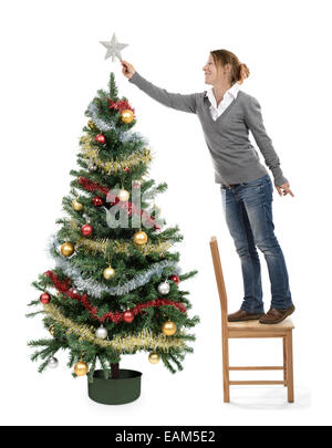 Ornements de décoration arbre de Noël femme mettre une étoile sur l'arbre haut de page Banque D'Images