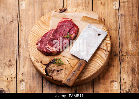 Ribeye Steak cru viande fraîche et viande cleaver sur fond de bois Banque D'Images