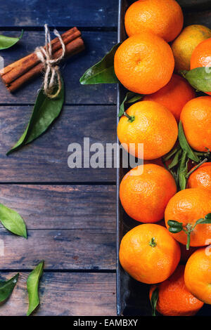 Mandarines avec les feuilles et le bâton de cannelle sur la vieille table en bois. Vue d'en haut. Banque D'Images