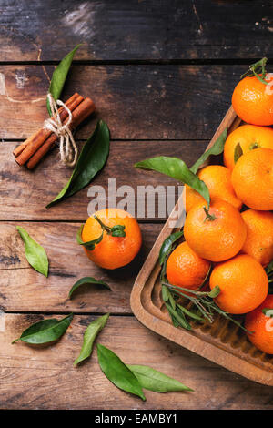 Mandarines avec les feuilles et le bâton de cannelle sur la vieille table en bois. Vue d'en haut. Banque D'Images