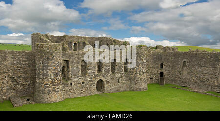 Intérieur de l'impressionnant château de Beaumaris avec de hautes tours et murs entourant une cour herbeuse sous ciel bleu au Pays de Galles Banque D'Images