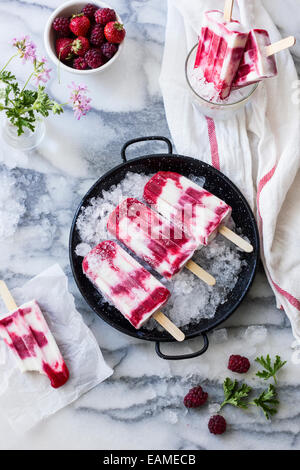 Sucettes glacées au yogourt Berry sur Vintage casserole et dessus marbre Banque D'Images