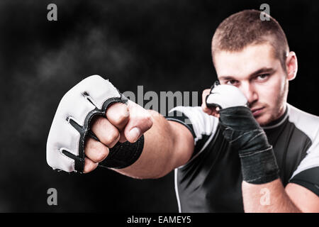 Un jeune kickboxer ou posant plus de boxer un fond sombre Banque D'Images