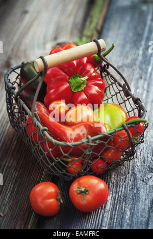 Les poivrons et les tomates sur un fond de bois Banque D'Images