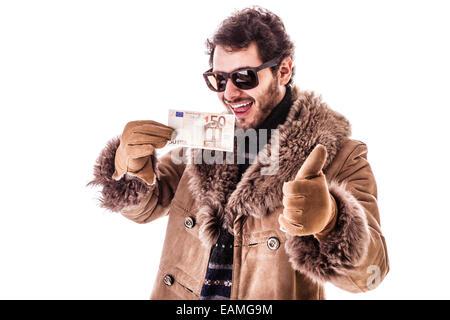 Un jeune homme portant un manteau en peau de mouton isolé sur un fond blanc holding banknotes Banque D'Images
