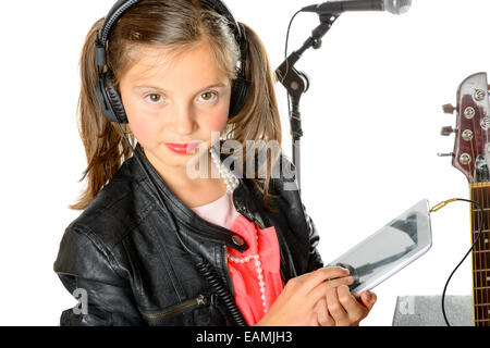 Une jeune fille à l'écoute de la musique sur sa tablette numérique et écouteurs Banque D'Images