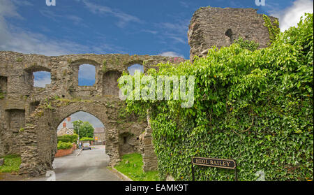 Ruines de l'ancienne porterie du château de Kidwelly avec aperçu de village moderne au-delà du ciel bleu à la hausse d'archway Banque D'Images