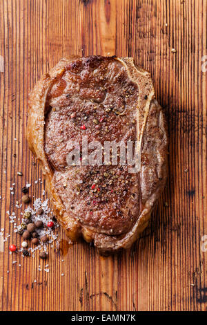 Ribeye Steak grillé la viande fraîche et l'assaisonnement sur fond de bois Banque D'Images