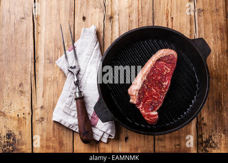 Grillades de bœuf premium d'Amérique du Sud New York steak sur grill pan sur fond de bois Banque D'Images