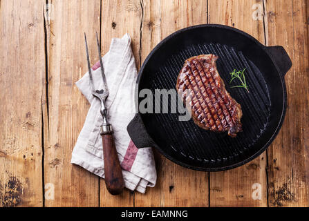 Grillades de bœuf premium d'Amérique du Sud New York steak sur grill pan sur fond de bois Banque D'Images