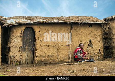 Femme africaine à partir de la tribu Masai travaillant devant sa maison de village Banque D'Images