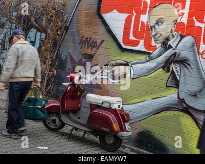 Francfort-sur-Main, Allemagne. 18 Nov, 2014. Un homme avec des ciseaux géant sur une coupe 'graffiti' le guidon d'un scooter stationné à Francfort-sur-Main, Allemagne, 18 novembre 2014. Photo : FRANK RUMPENHORST/dpa/Alamy Live News Banque D'Images