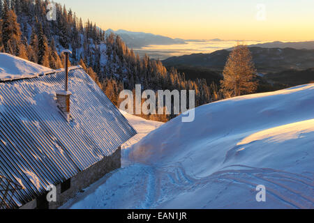 Lever du soleil d'hiver, refuge de montagne dans les Alpes slovènes, Blejska koca. Banque D'Images