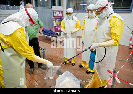 Würzburg, Allemagne. 06Th Nov, 2014. Martin Horn (R), participant à un séminaire de formation d'Ebola, désinfecte un échantillon au cours d'un atelier sur la préparation pour le service dans les zones de crise à Würzburg, Allemagne, 03 novembre 2014. Après les Forces armées fédérales, Wuerzberg possède le seul centre de formation d'Ebola à date. L'aide allemande-travailleurs dans les zones de crise et en allemand ici train stations d'isolement. Photo : DANIEL KARMANN/dpa/Alamy Live News Banque D'Images