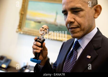 Le président américain Barack Obama détient une poupée figurine de lui-même dans l'avant-Bureau ovale de la Maison Blanche le 14 mai 2014 à Washington, DC. Banque D'Images