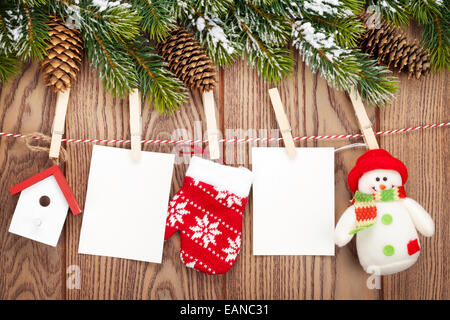 Sapin de neige, cadres photo et décoration de Noël sur corde sur planche en bois rustique avec copie espace Banque D'Images