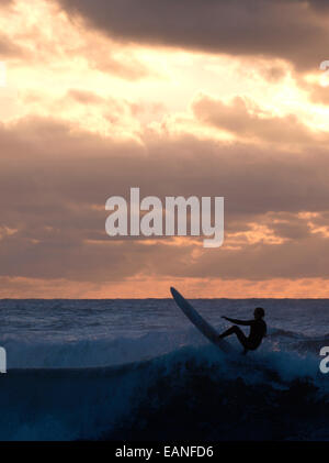 Surfer au coucher du soleil, Bude, Cornwall, UK Banque D'Images