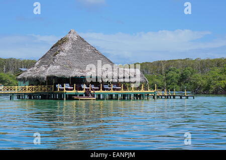 Le restaurant Tropical avec toit de chaume au-dessus de l'eau de la mer des Caraïbes, l'Amérique centrale Banque D'Images