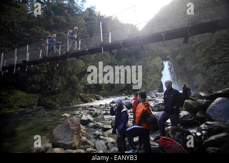 Les marcheurs reste en dessous de la passerelle au Giants Gate Falls sur le Milford Track, Nouvelle-Zélande Banque D'Images