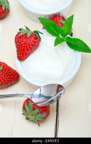Yaourt à la Grecque biologique et de fraise sur la table rustique en bois blanc Banque D'Images