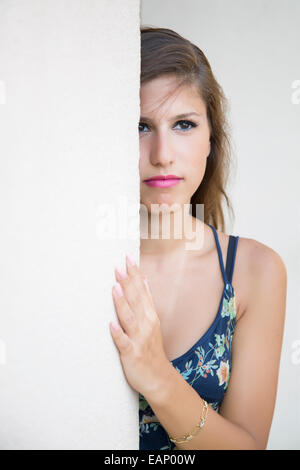 Belle jeune femme peeking derrière Banque D'Images