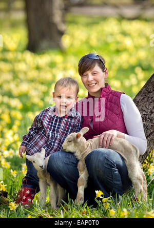 Un éleveur de Kempley, Gloucestershire avec son fils âgé d'un an et certains de leurs agneaux de printemps UK Banque D'Images