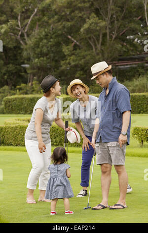 Sur un terrain de golf de la famille.Un enfant et trois adultes. Banque D'Images