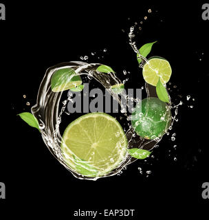 Limes fraîches dans de l'eau splash, isolé sur fond noir Banque D'Images