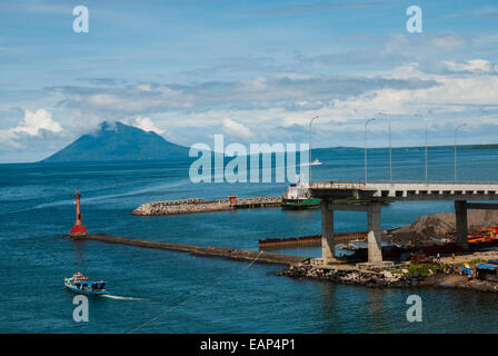 Vue sur la baie de Manado avec le mont Manado Tua au premier plan d'un phare et d'une partie d'un pont en construction à Manado, en Indonésie. Banque D'Images