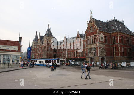 Les gens qui marchent en face de la Gare Centrale d'Amsterdam CS, comme vu de la Stationsplein (place de la gare) Banque D'Images