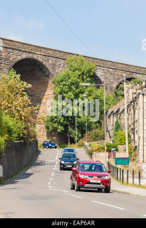 Les véhicules circulant sous un viaduc, l'un des deux viaducs de chemin de fer à Milton, chapelle, Derbyshire Peak District, England, UK Banque D'Images