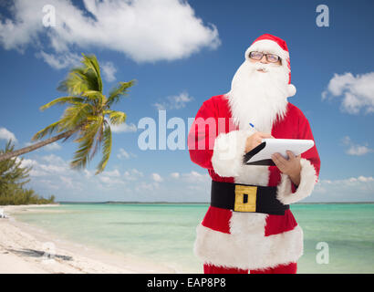 L'homme en costume de Père Noël avec le bloc-notes Banque D'Images