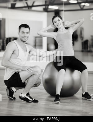 Male trainer avec femme faisant des craquements sur la balle Banque D'Images
