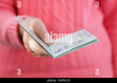Une femme plus âgée, présentant un passeport britannique pour la vérification au contrôle des passeports à l'étranger. Angleterre Royaume-uni Grande-Bretagne Banque D'Images